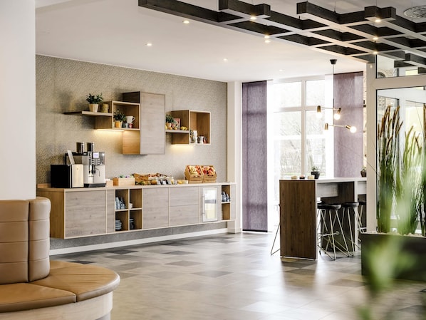 Une cuisine moderne dotée d’appareils électroménagers intégrés, de meubles de rangement en bois et d’un coin bar avec des tabourets.