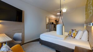 A modern hotel room with a bed, a desk, a chair, and a TV. - Mercure Hotel Stuttgart Gerlingen (Gerlingen)