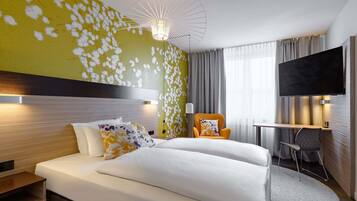 A hotel room with a bed, a desk, a chair, a TV, and a unique wall design.
