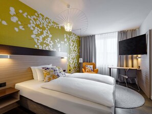 A hotel room with a bed, a desk, a chair, a TV, and a unique wall design. - Mercure Hotel Stuttgart Gerlingen (Gerlingen)