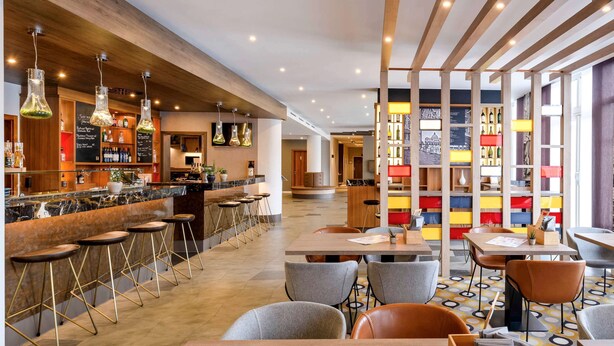 A modern bar area with a marble countertop, stools, and hanging pendant lights. - Mercure Hotel Stuttgart Gerlingen (Gerlingen)