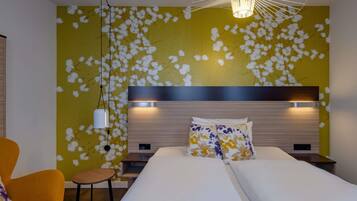 A modern hotel room with a large bed, a small table, a chair, and a unique wall design.