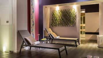 Relax in a serene space with two reclining chairs and a soothing green wall.