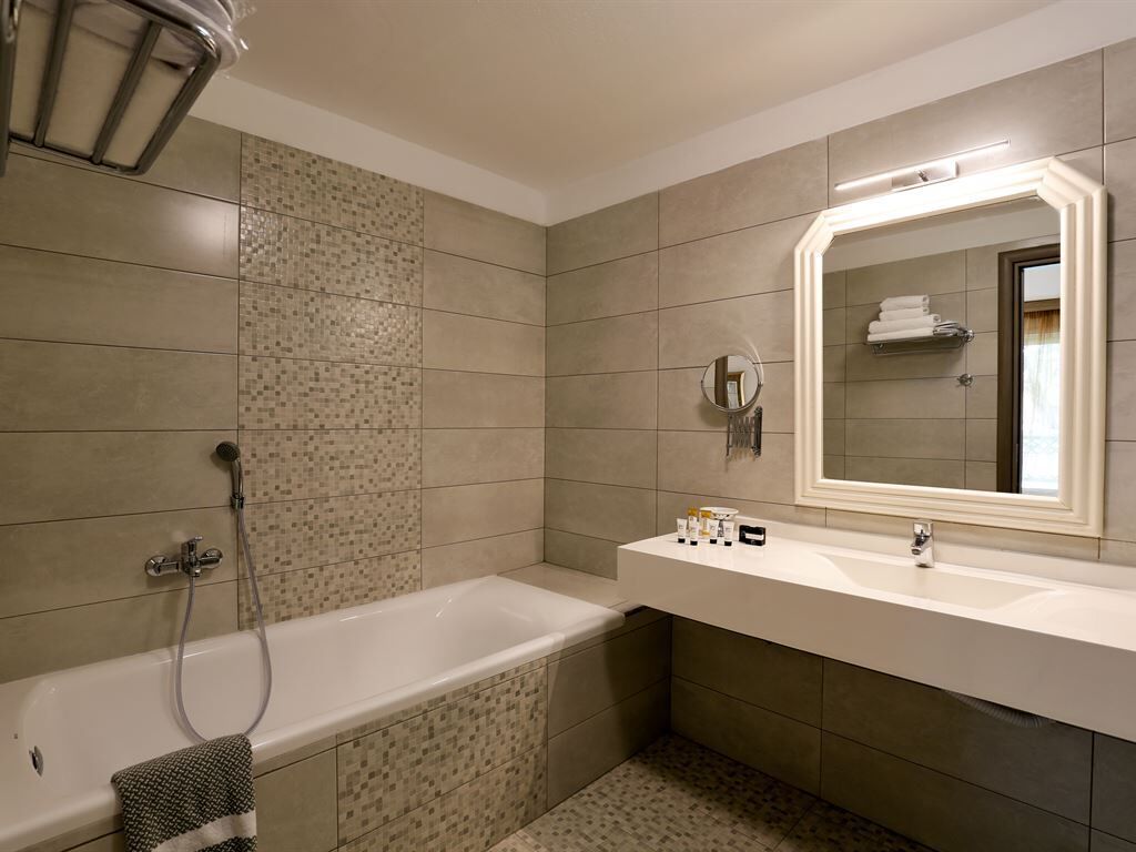 A modern bathroom with a bathtub, a sink, and a mirror.