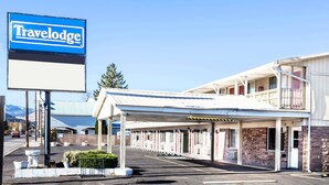 A Travelodge motel with a covered parking area and a row of rooms with balconies. - Travelodge by Wyndham La Grande (La Grande)