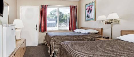 A hotel room with two beds, a television, a desk with a lamp, a window with curtains, and a painting on the wall.