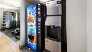 A vending machine with a Pepsi logo, a water dispenser, and a refrigerator with a digital display. - Red Roof Inn Morton Grove (Morton Grove)