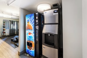 A vending machine with a Pepsi logo, a water dispenser, and a refrigerator with a digital display. - Red Roof Inn Morton Grove (Morton Grove)
