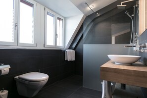 Deluxe tweepersoonskamer | Badkamer | Een douche, een haardroger, handdoeken