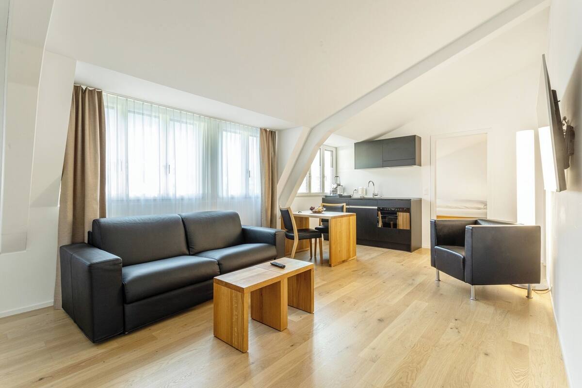 Um apartamento moderno com sala de estar, área de refeições e cozinha.