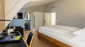 Un dormitorio con cama, escritorio, silla y armario.