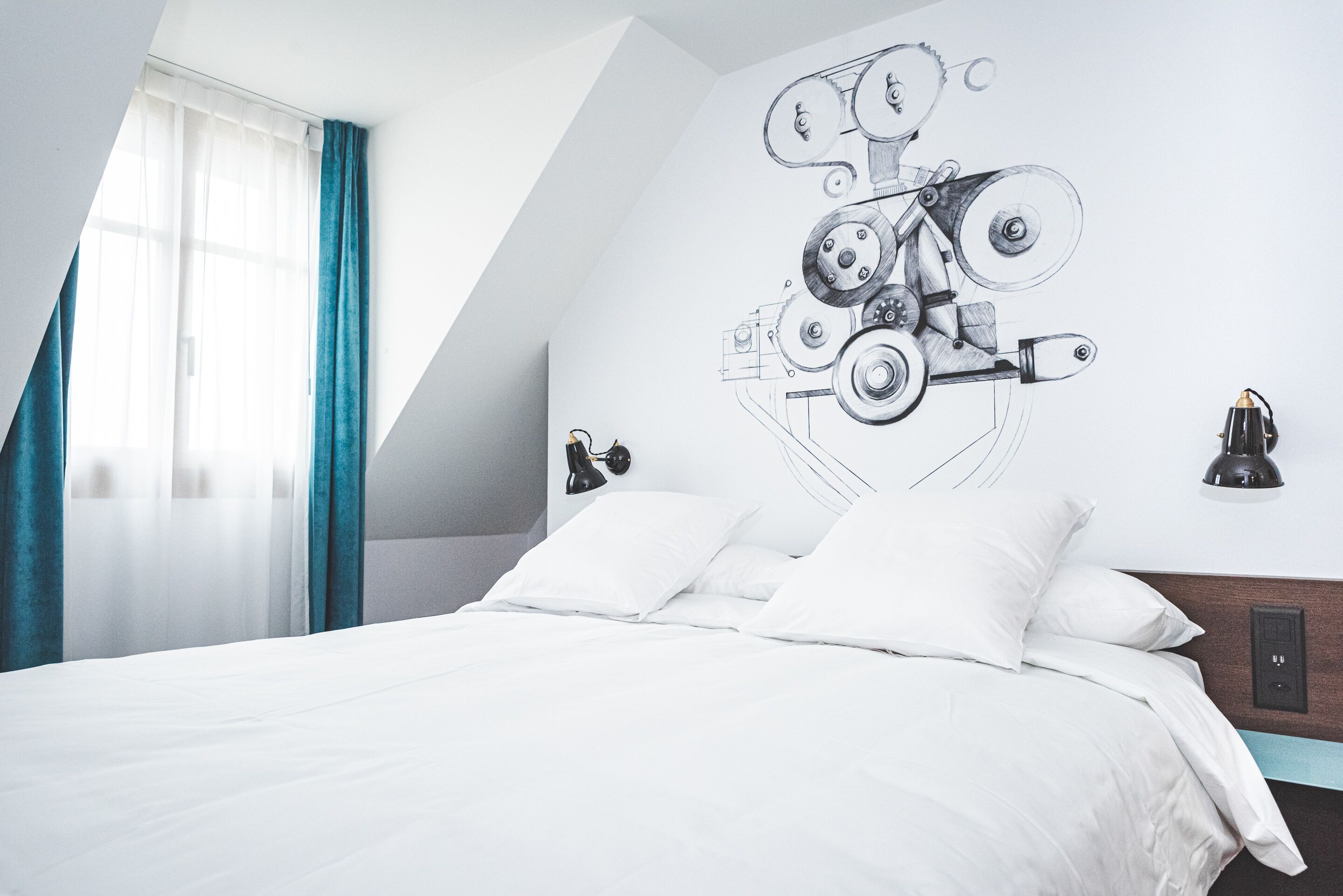 A modern bedroom with a bed, white bedding, a wall-mounted lamp, and a ceiling fan.