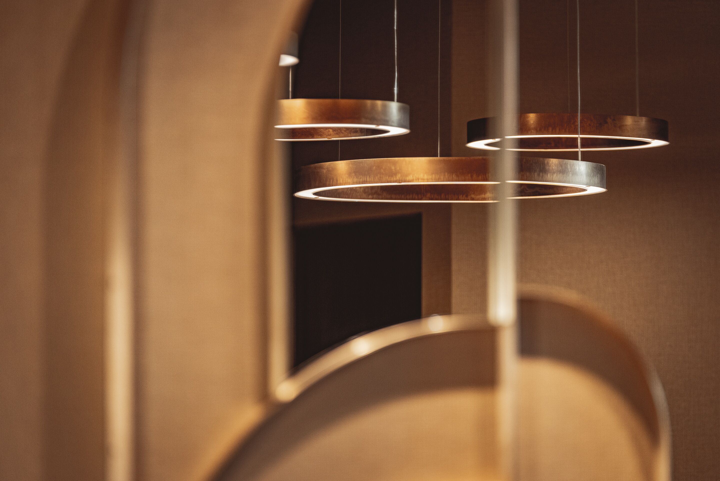 A modern interior with circular light fixtures and a curved architectural design.