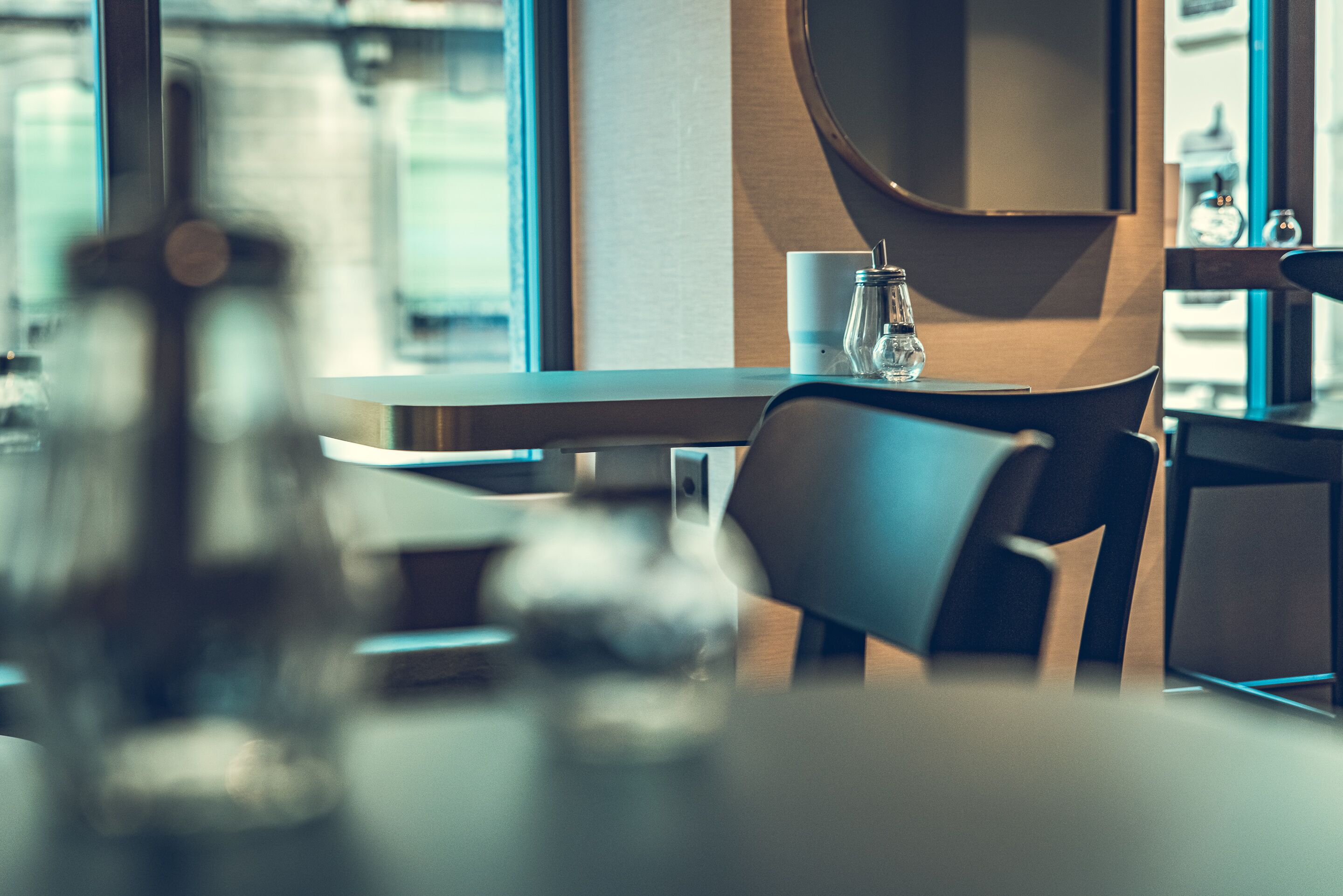 Un comedor moderno con una mesa, sillas y un vaso de agua.