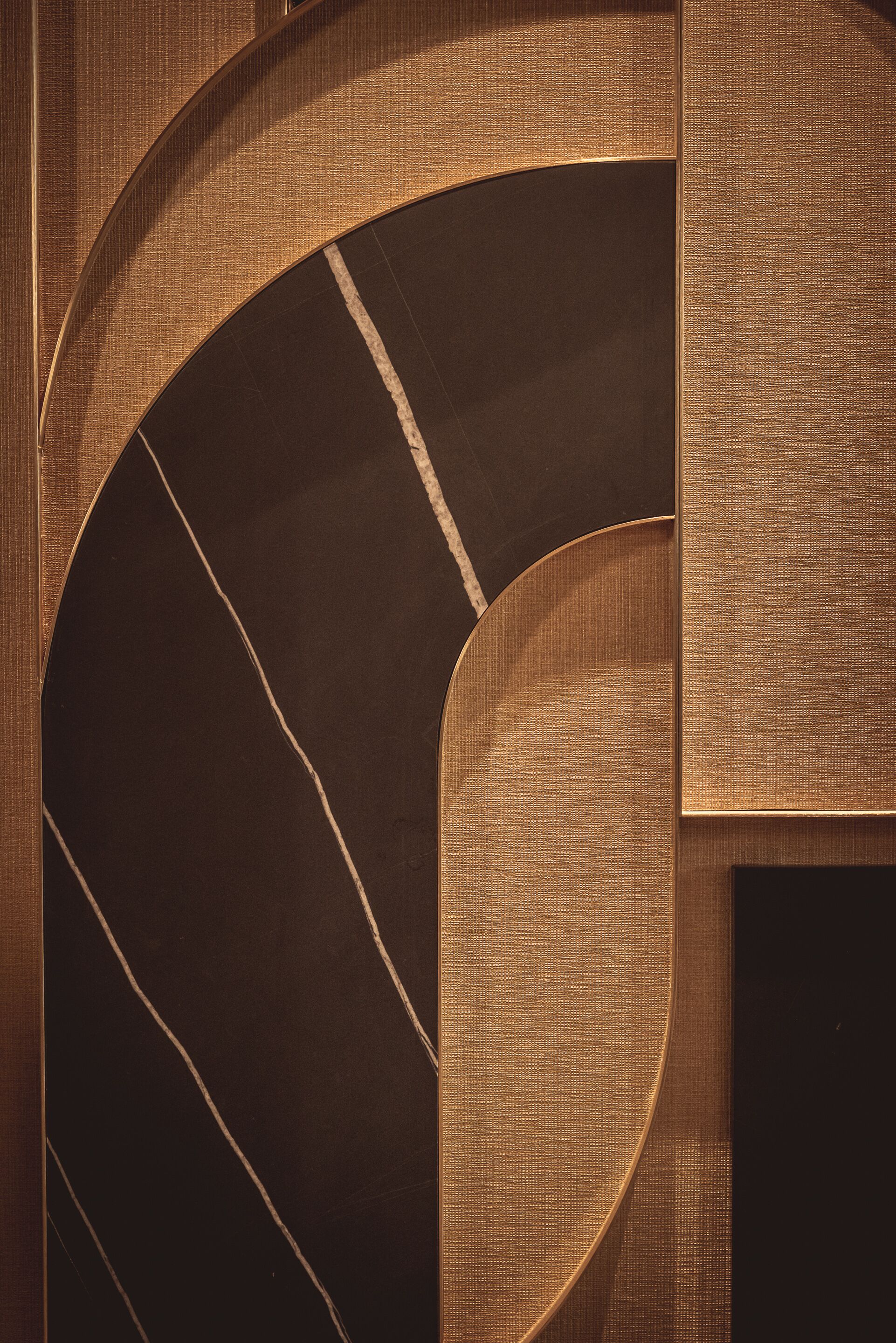 A curved architectural feature with a textured surface and a dark, reflective floor.