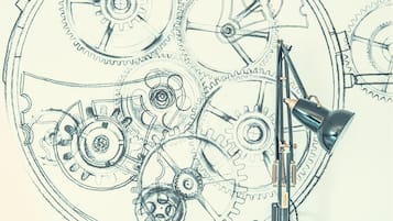 A detailed mechanical drawing of interlocking gears with a drafting lamp positioned to the right.