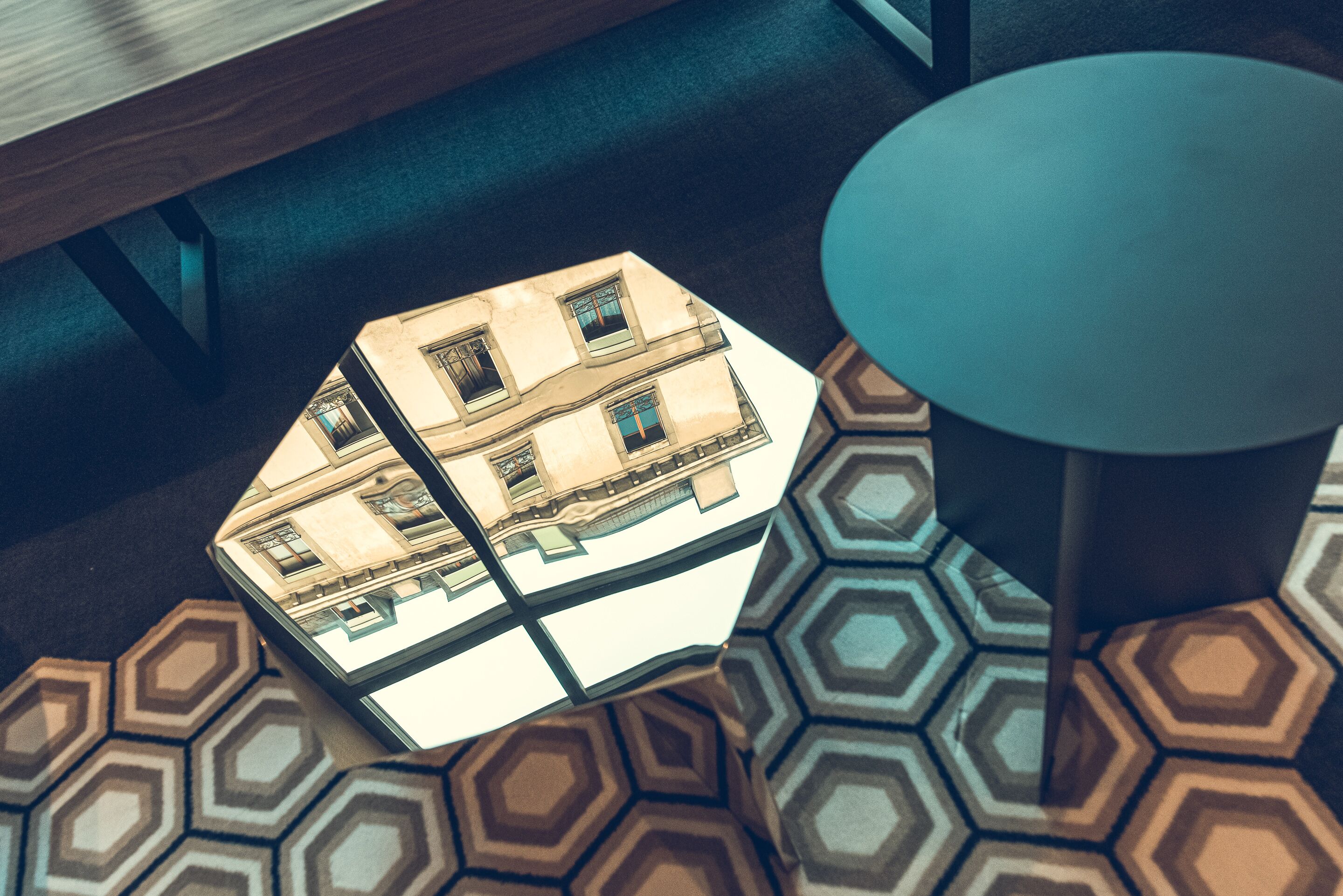 Un sol orné d’un motif hexagonal, une table ronde et une maquette de bâtiment.