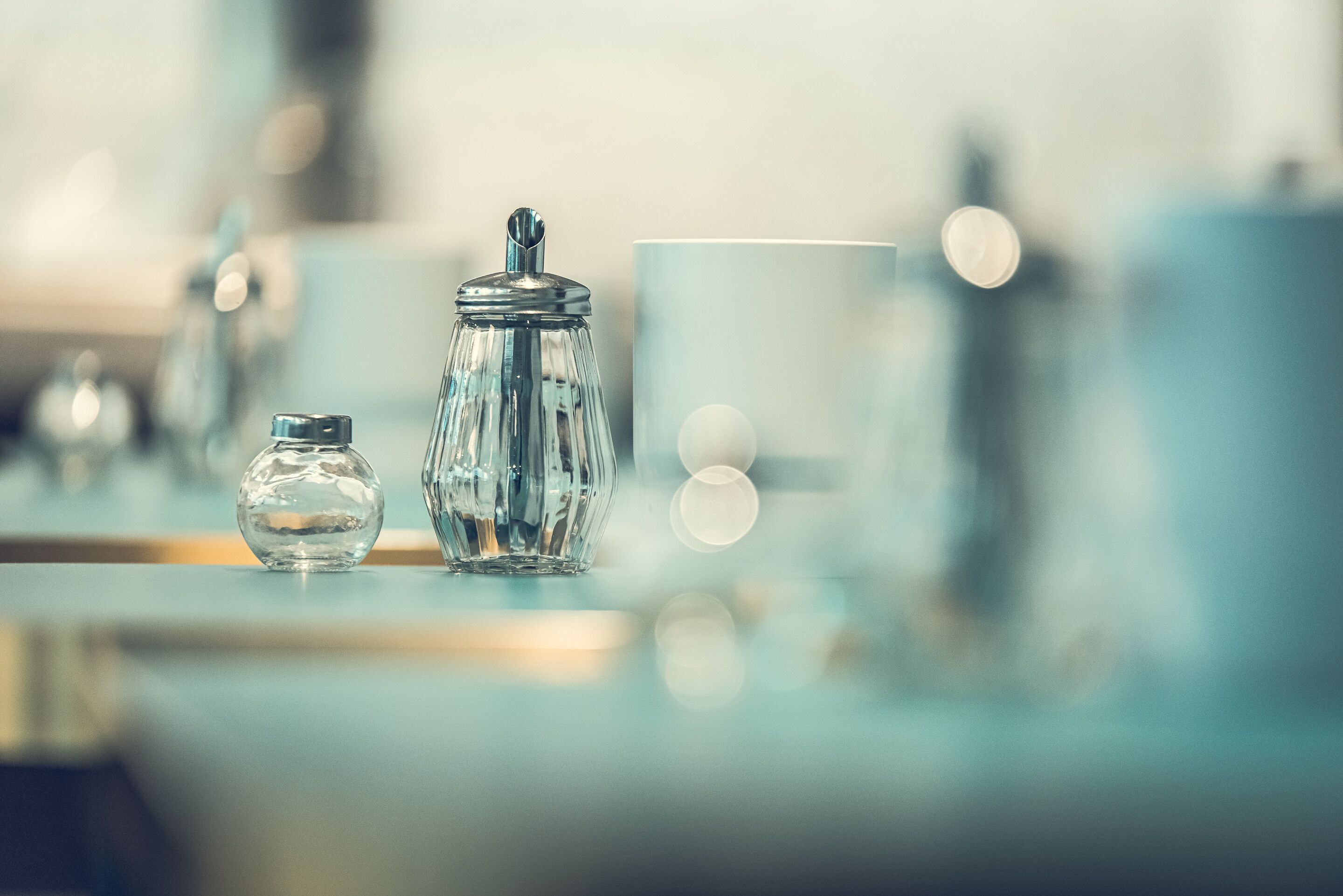 A modern, well-lit room with a clear glass jar and a matching container on a reflective surface, suggesting a clean and contemporary design.