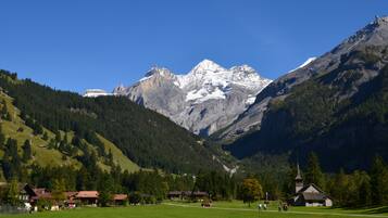 A mountain landscape with a church and houses in a valley.