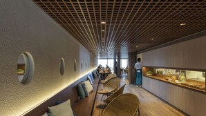 A modern interior with a long bench seating area, a kitchen counter, and a patterned ceiling. - Hotel Arpoador (Rio de Janeiro)