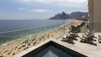 Una piscina al aire libre, sillones reclinables de piscina