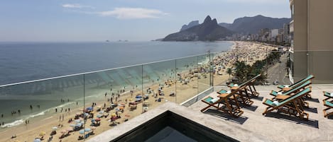 Una piscina al aire libre, sillones reclinables de piscina