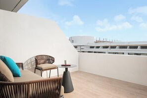 A balcony with wicker furniture, a round table, and a view of the ship's deck. - Amari Don Muang Airport Bangkok (Bangkok)