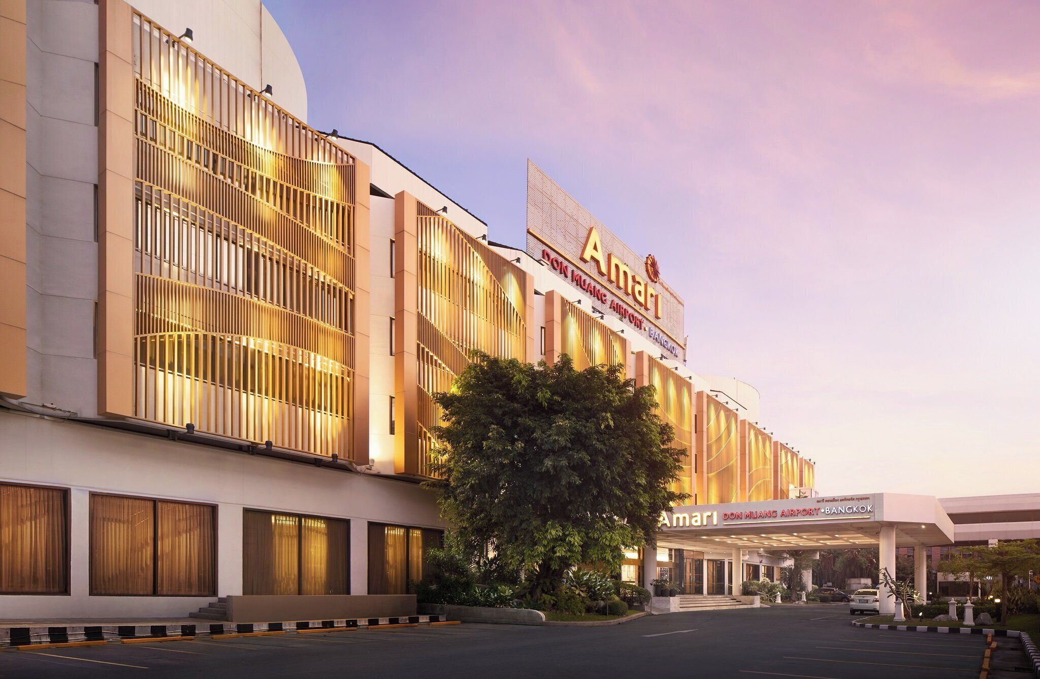 A modern building with a large sign reading "Amari Don Muang Airport Bangkok".