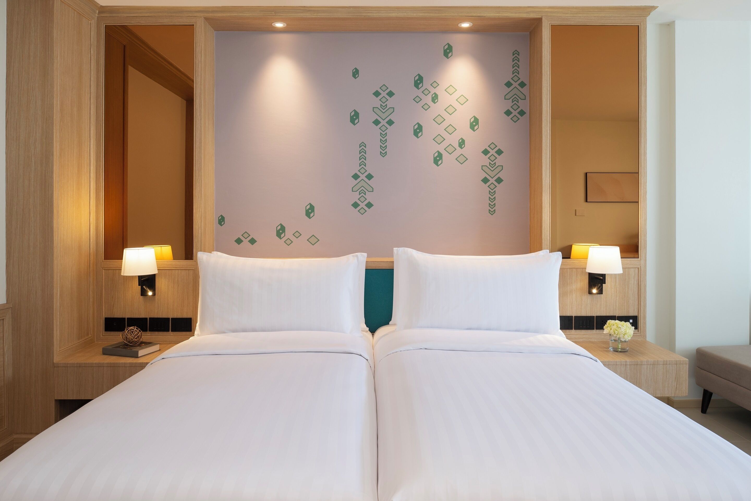 A double bed with two bedside tables, each with a lamp and a small decorative item.