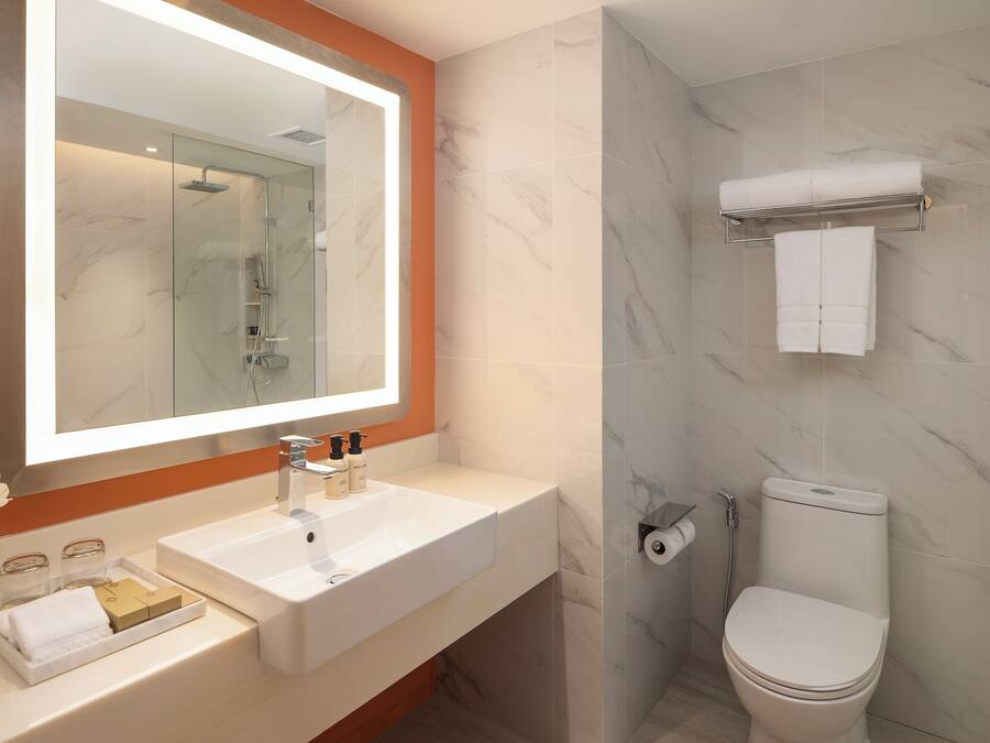 Ein Badezimmer mit Waschbecken, Spiegel, Toilette und Dusche.