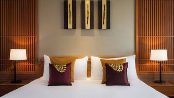 Une chambre d’hôtel avec un grand lit, deux lampes de chevet et une œuvre d’art accrochée au mur au-dessus du lit.