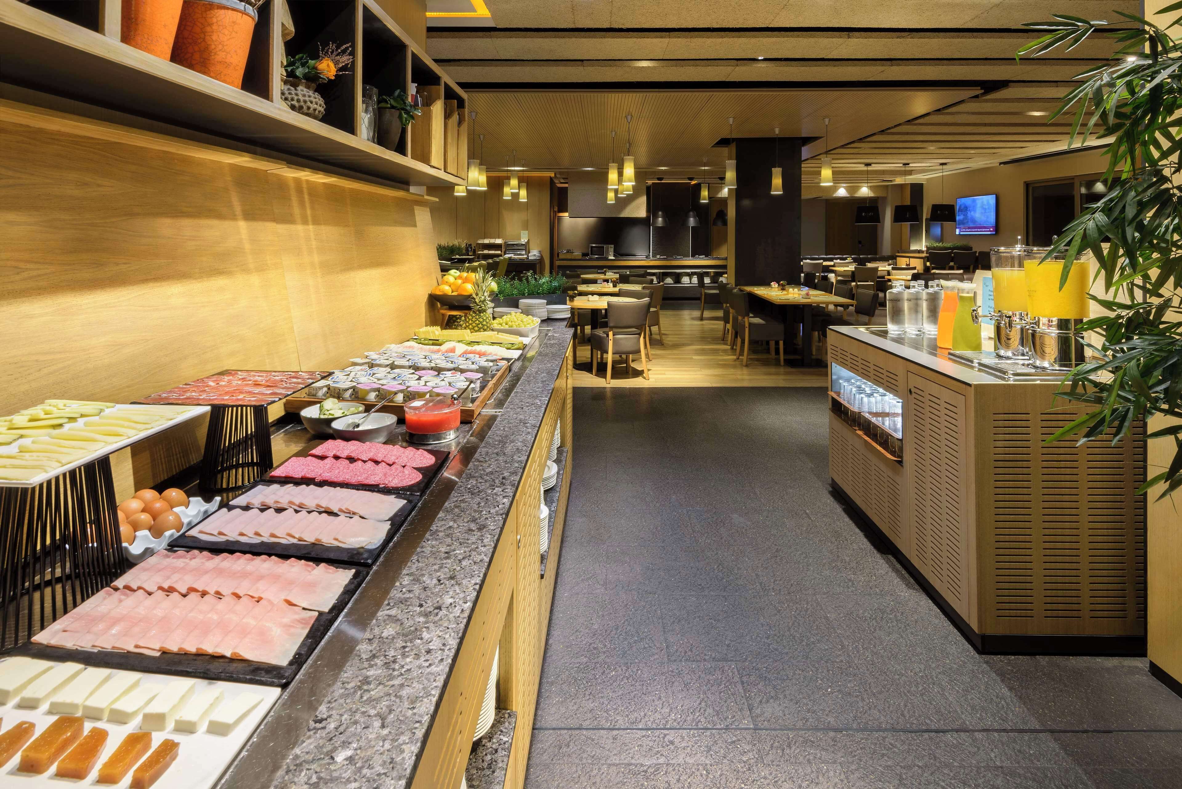 A buffet area with various food options and a seating area with tables and chairs.