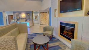 A modern living room with a fireplace, sofas, and a coffee table. - Holiday Inn Express & Suites Blacksburg - University Area by IHG (Blacksburg)