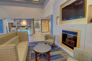 Una sala de estar moderna con chimenea, sofás y una mesa de centro.