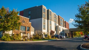 A multi-story building with a parking lot in front. - Holiday Inn Express & Suites Blacksburg - University Area by IHG (Blacksburg)