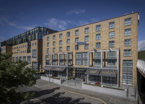 A modern hotel with multiple floors, a prominent Hilton sign, and a storefront named "The Sixth Lock Bar & Restaurant" at the ground level. - Hilton Dublin (Dublin)