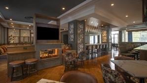 A bar area with a fireplace, seating, and a television. - Hilton Dublin (Dublin)