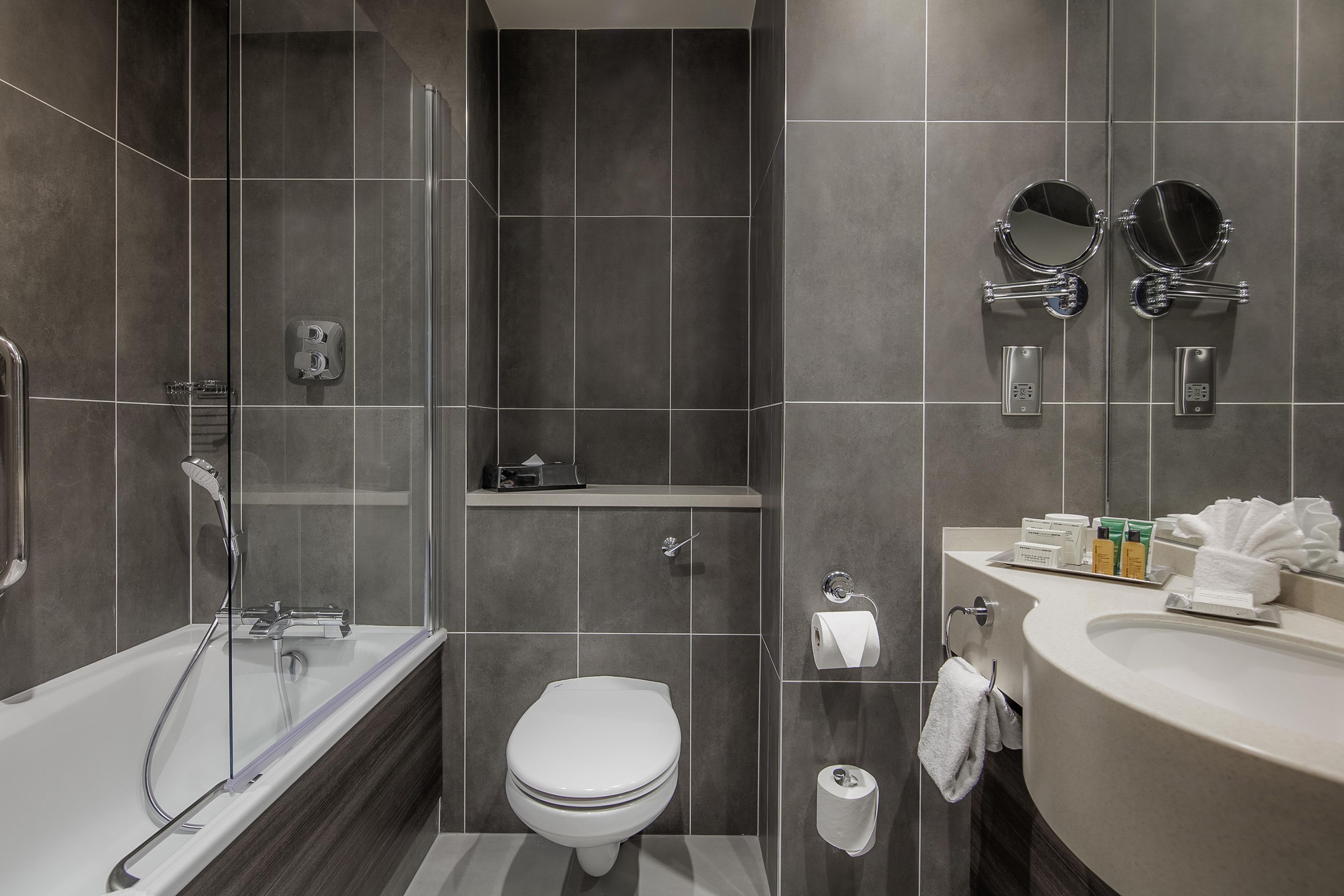 Un baño moderno con ducha, inodoro y lavamanos.