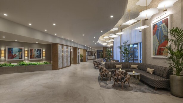 A spacious lobby with modern furnishings, a reception desk, and artwork on the walls. - Hilton Dublin (Dublin)