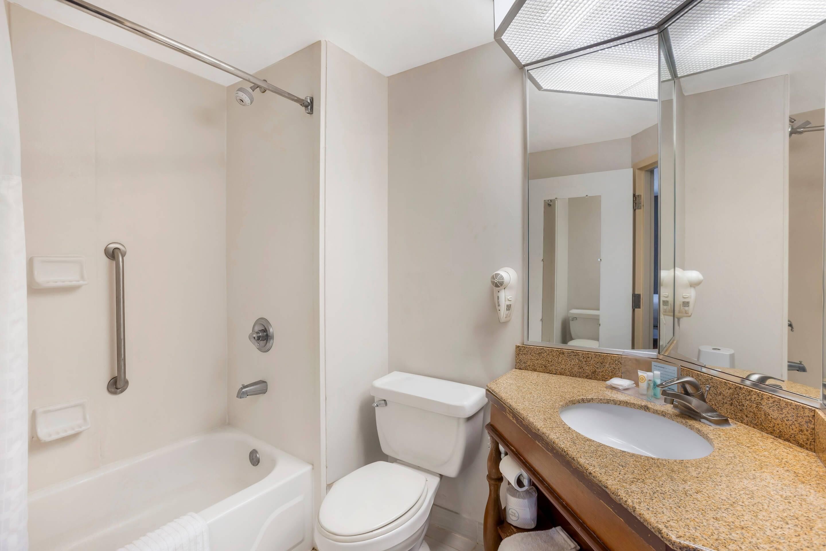 A modern bathroom with a bathtub, toilet, and sink.
