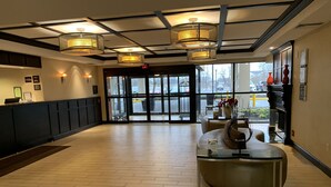 A spacious lobby with a reception desk, a glass coffee table, and a view of the parking area through large windows. - Comfort Inn & Suites Mt. Holly - Westampton (Mount Holly)