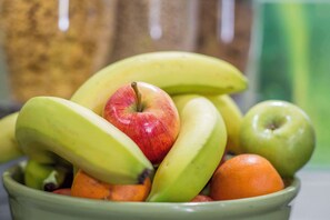 A bowl of fruit including bananas, apples, and oranges.