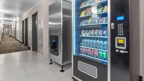 Ein Hotelgang mit Getränke- und Snackautomaten, Wasserspender und Mikrowelle.