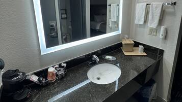 Une salle de bain moderne avec un grand miroir, un lavabo et un porte-serviettes.