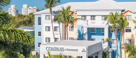 A multi-story hotel with a sign reading "Compass by Margaritaville All Suites".
