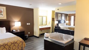 Ein Hotelzimmer mit einem Bett, einem Badezimmer mit Badewanne, Waschtisch und Spiegel.