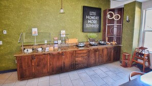A kitchen area with a wooden counter, a sign that reads "LESS MONDAY MORE SUMMER," and a small stool. - Fairfield Inn & Suites by Marriott Grand Junction Downtown (Grand Junction)