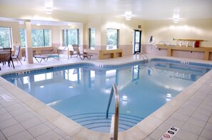 An indoor swimming pool with clear water, a tiled deck, and a lifeguard chair. - Best Western Plus Kalamazoo Suites (Kalamazoo)