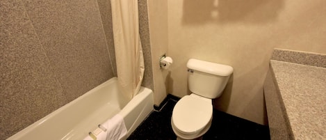 A bathroom with a bathtub, toilet, and a towel rack.