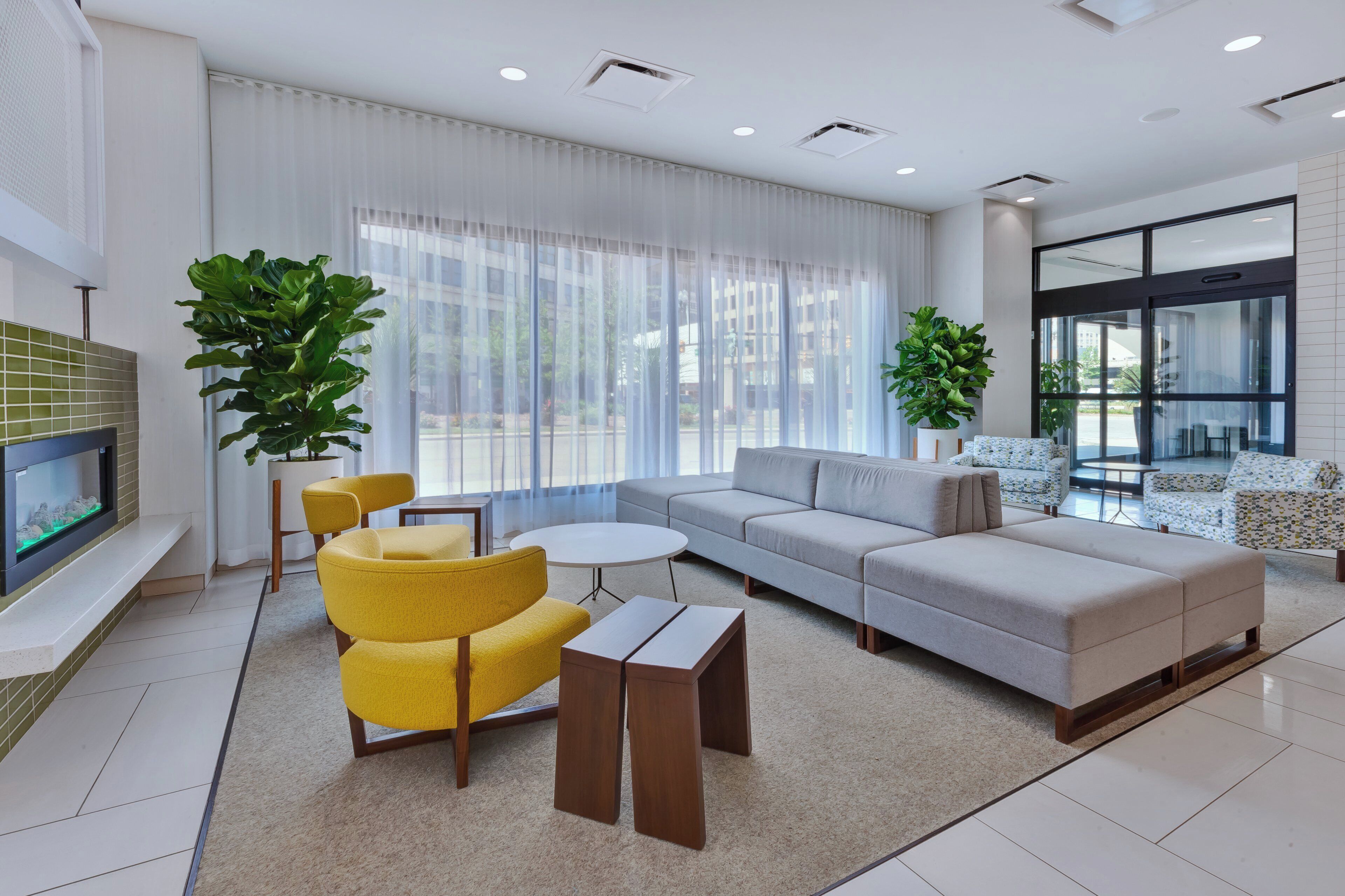 Uma sala de estar moderna com sofá, cadeiras, mesa de centro e lareira.